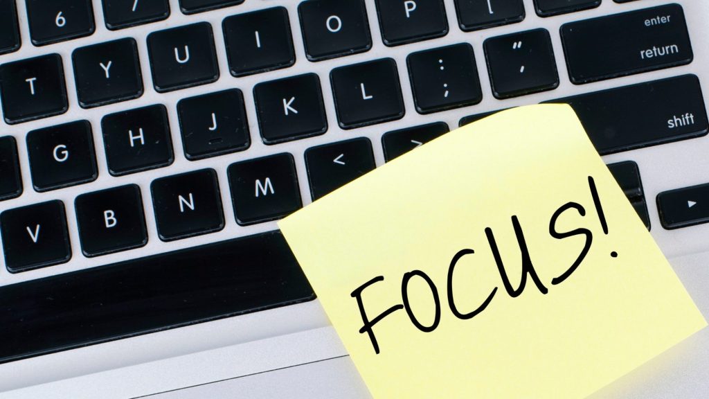 Foto von Tastatur mit Post-it mit dem Text "Focus" als Symbol für Fokussiertes Arbeiten